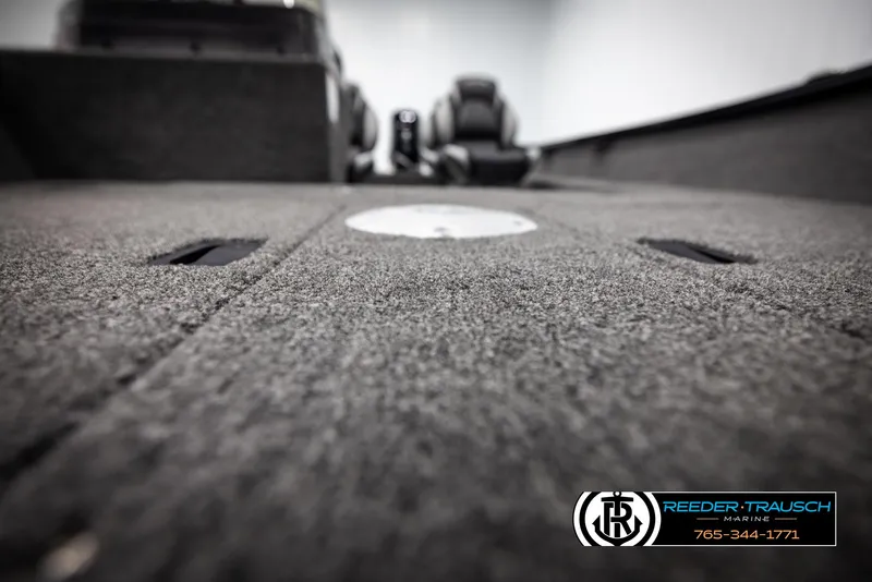 Slide: The Image of 2025 Lund 1650 Rebel XL SS boat interior with carpeted flooring, Reeder-Trausch Marine logo. - 27