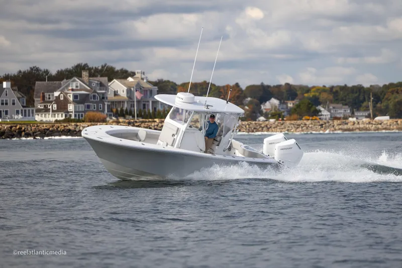 Slide: The Image of 2024 Onslow Bay 27XS boat cruising near coastal homes. - 11