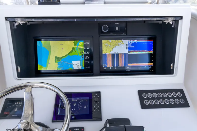 Slide: The Image of 2024 Onslow Bay 27XS boat dashboard with navigation screens and controls. - 13