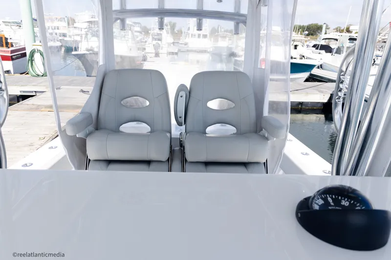 Slide: The Image of 2024 Onslow Bay 27XS boat interior with dual seats and compass at marina. - 15