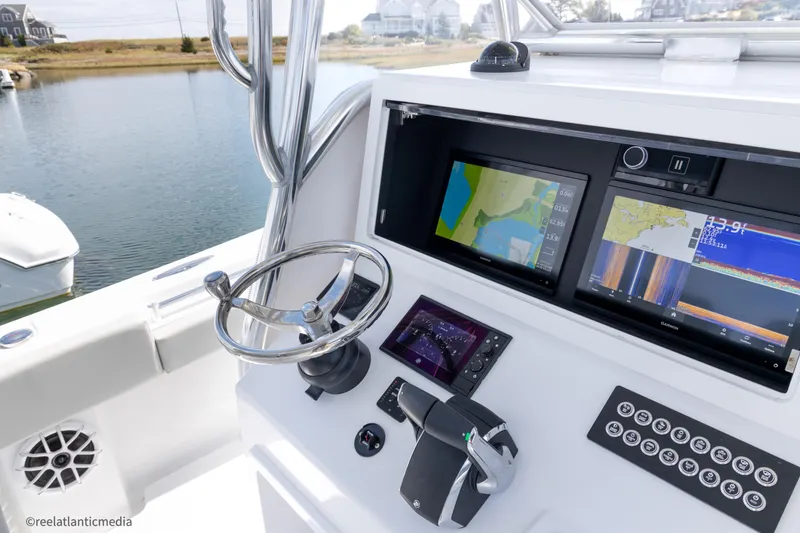 Slide: The Image of 2024 Onslow Bay 27XS boat dashboard with navigation screens and controls. - 17