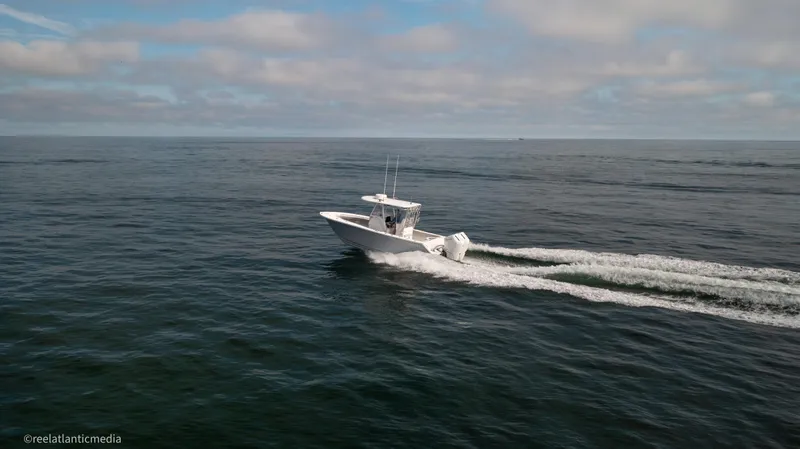 Slide: The Image of 2024 Onslow Bay 27XS boat cruising on open ocean under cloudy sky. - 18