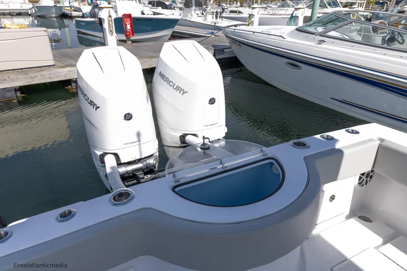 Slide: The Image of 2024 Onslow Bay 27XS boat with twin Mercury engines at a marina. - 19
