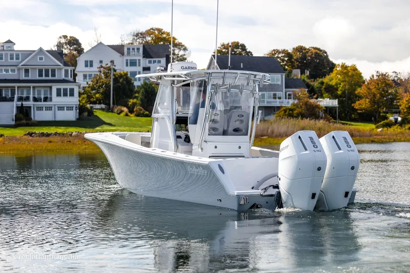 Slide: The Image of 2024 Onslow Bay 27XS boat with dual engines on a scenic waterway. - 2