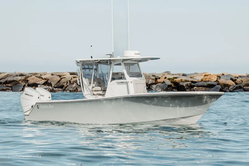 Slide: The Image of 2024 Onslow Bay 27XS boat on water near rocky shoreline. - 24