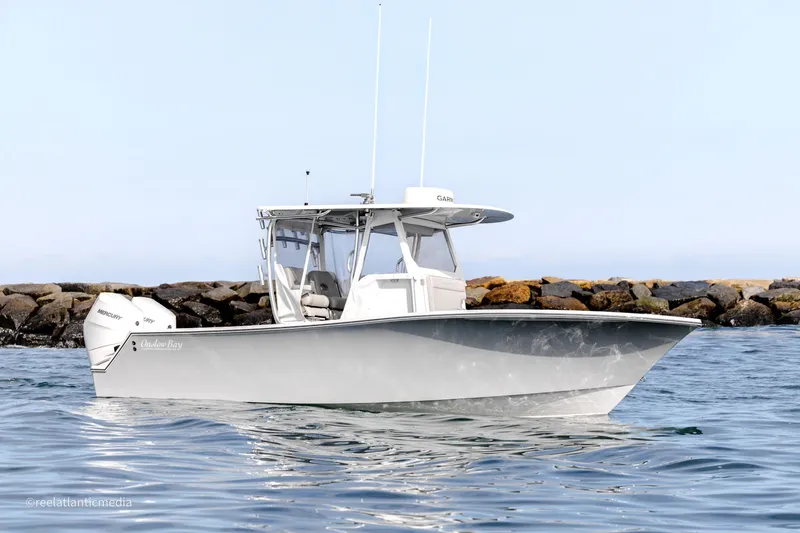 Slide: The Image of 2024 Onslow Bay 27XS boat on calm water near rocky shore. - 25