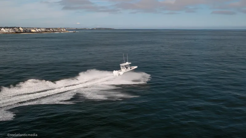 Slide: The Image of 2024 Onslow Bay 27XS boat speeding across open water. - 28