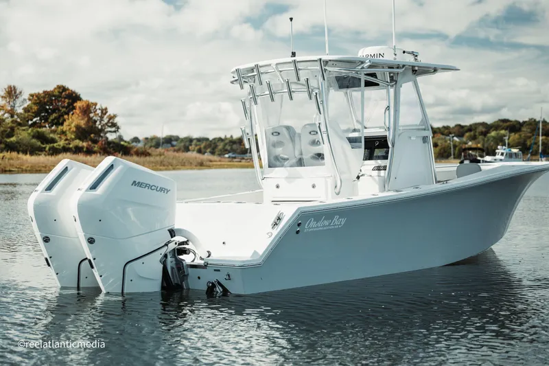 Slide: The Image of 2024 Onslow Bay 27XS boat with twin Mercury engines on calm water. - 8