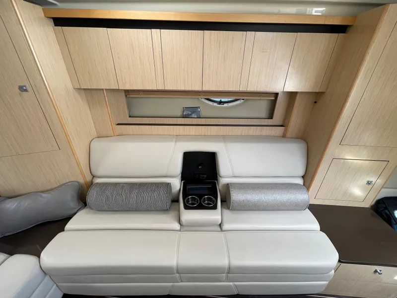 Slide: The Image of Interior of 2016 Monterey 335 Sport Yacht with beige leather seating and wooden cabinetry. - 15