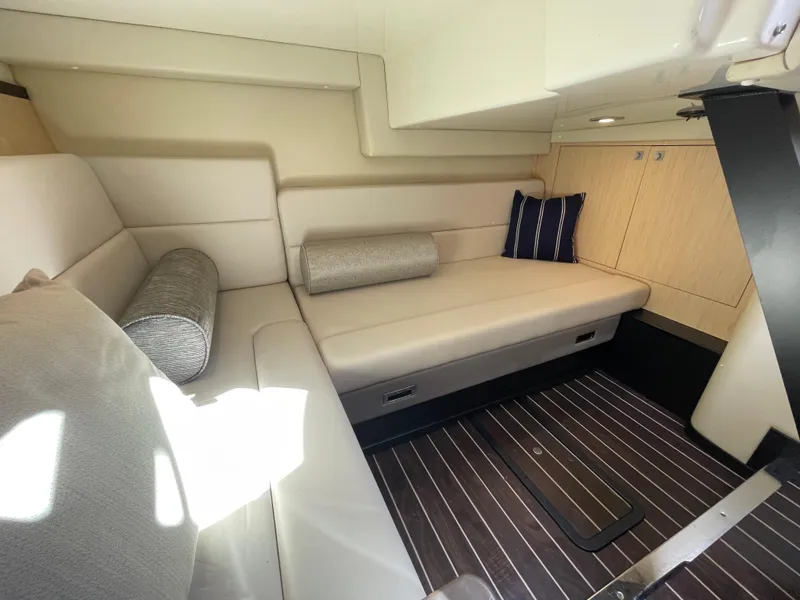 Slide: The Image of Interior of 2016 Monterey 335 Sport Yacht with beige seating and striped cushions. - 21