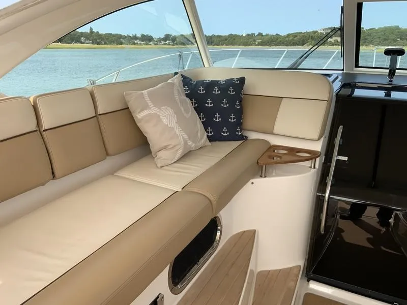 Slide: The Image of Luxurious interior of 2013 Tiara Yachts 36 with beige seating and nautical-themed pillows. - 12