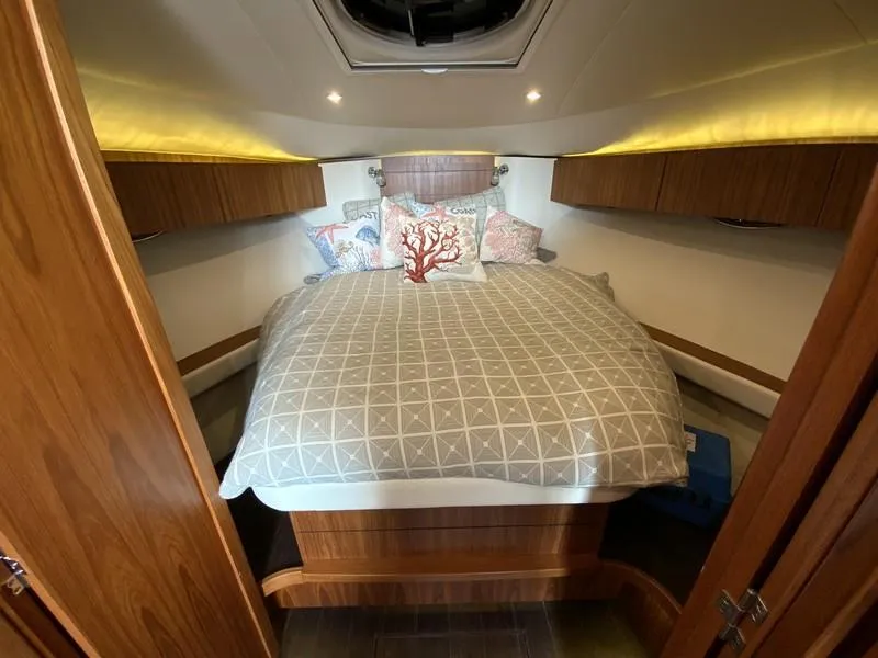 Slide: The Image of Luxurious cabin interior of 2013 Tiara Yachts 36 with cozy bedding and wood accents. - 18