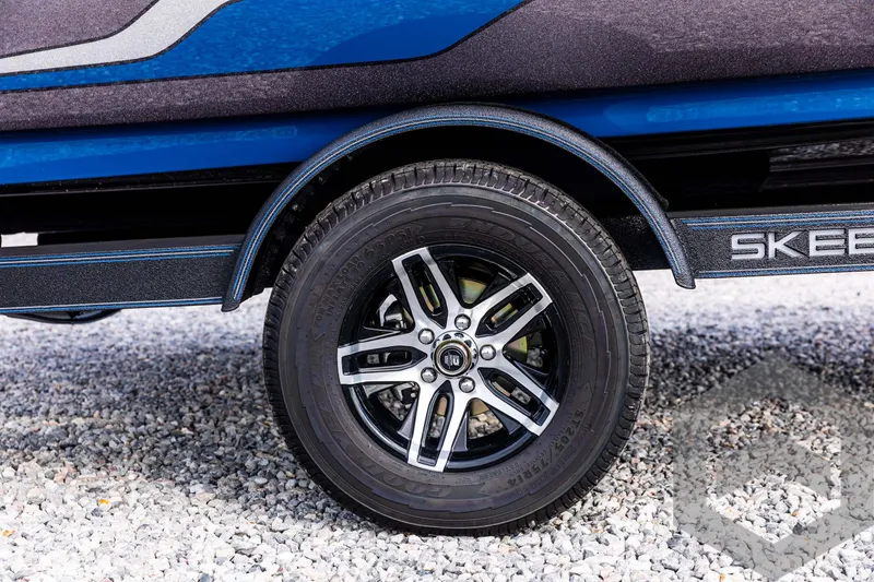 Slide: The Image of 2025 Skeeter ZX 150 trailer wheel on gravel surface. - 12