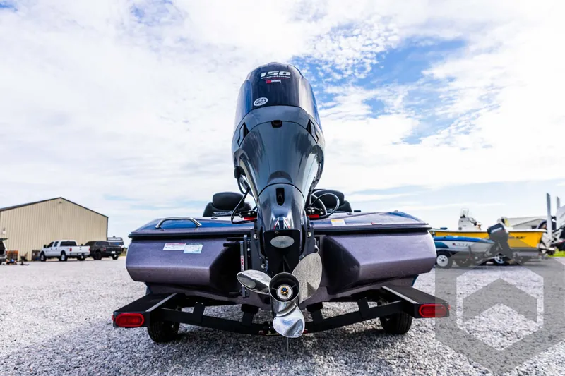 Slide: The Image of 2025 Skeeter ZX 150 boat rear view with outboard motor in a gravel lot. - 20