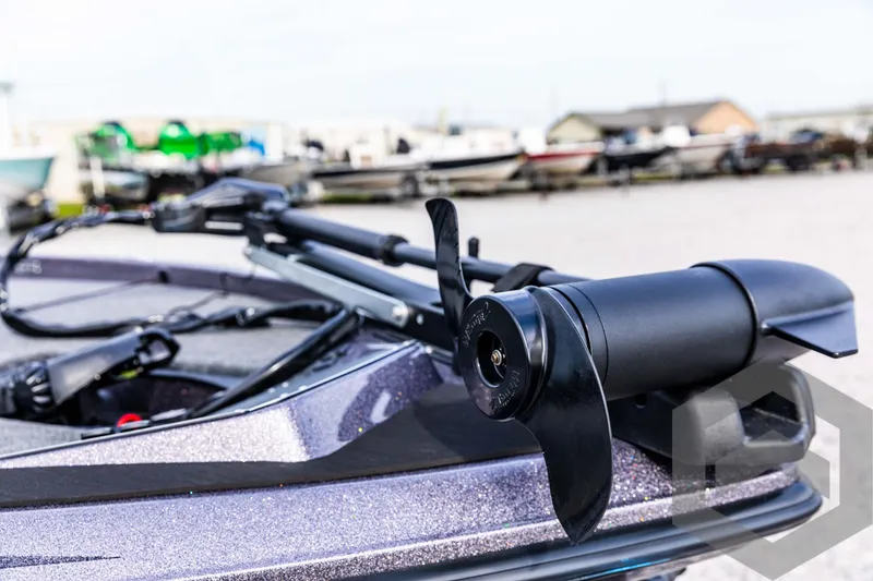 Slide: The Image of 2025 Skeeter ZX 150 boat with trolling motor in a marina setting. - 30