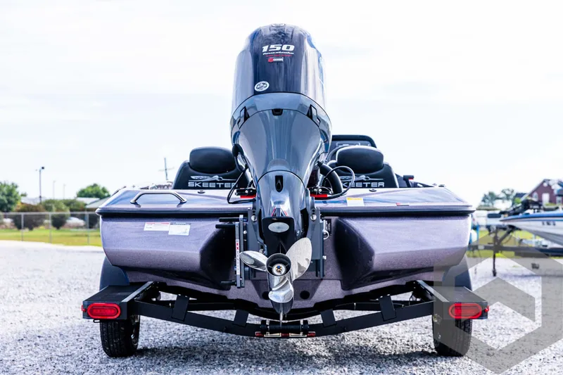 Slide: The Image of 2025 Skeeter ZX 150 boat with powerful outboard motor, rear view on gravel lot. - 7