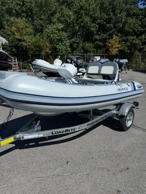 Slide: The Image of 2024 Highfield Classic 310 FCT inflatable boat on Load Rite trailer, parked outdoors. - 4