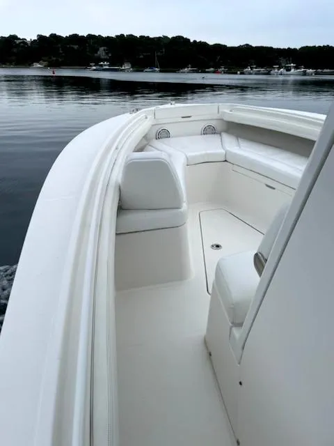 Slide: The Image of 2020 Regulator 23 FS boat on calm water, showcasing sleek design and spacious seating. - 11