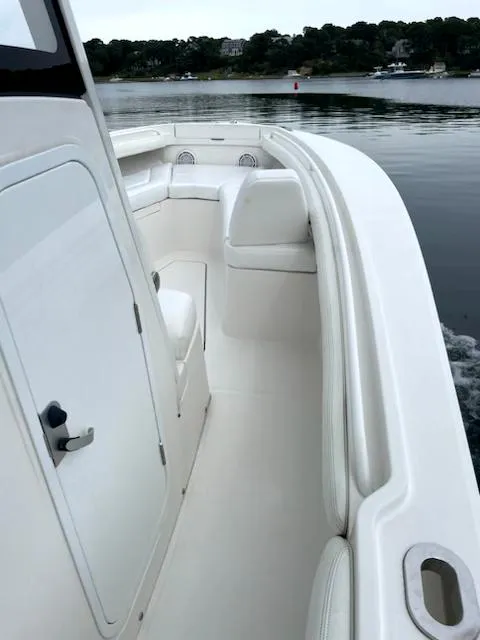 Slide: The Image of 2020 Regulator 23 FS boat on calm water, showcasing sleek white deck design. - 12