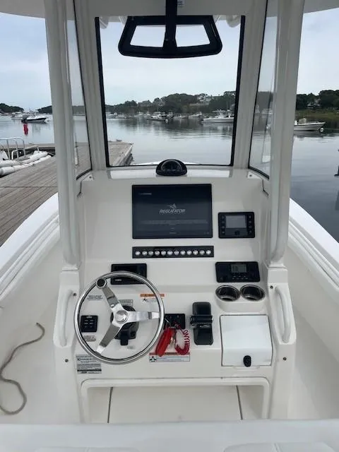 Slide: The Image of 2020 Regulator 23 FS boat console with steering wheel and navigation controls. - 8