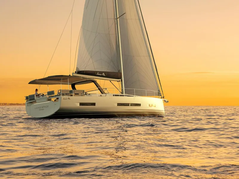Slide: The Image of 2025 Hanse 590 yacht sailing at sunset on calm waters. - 21