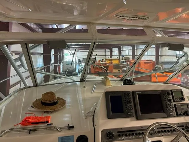 Slide: The Image of 2006 Rampage 33 Express boat interior with navigation equipment and straw hat on dashboard. - 13