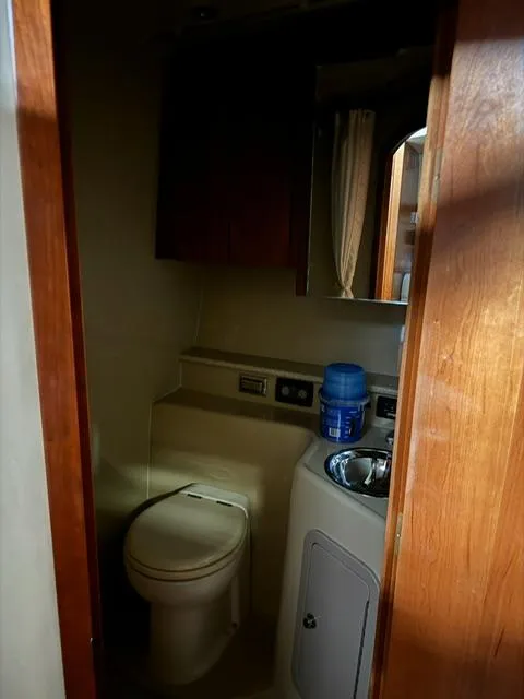 Slide: The Image of 2006 Rampage 33 Express boat bathroom with toilet, sink, and storage cabinet. - 15