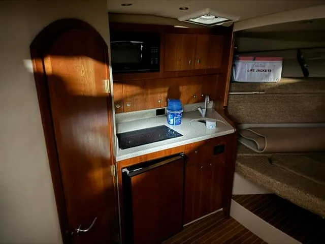 Slide: The Image of 2006 Rampage 33 Express cabin with kitchenette, microwave, and life jackets. - 16