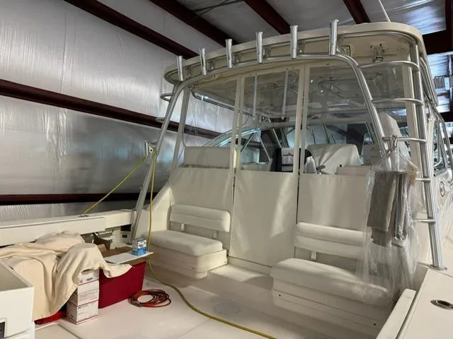 Slide: The Image of 2006 Rampage 33 Express boat interior in storage, featuring seating and fishing rod holders. - 3