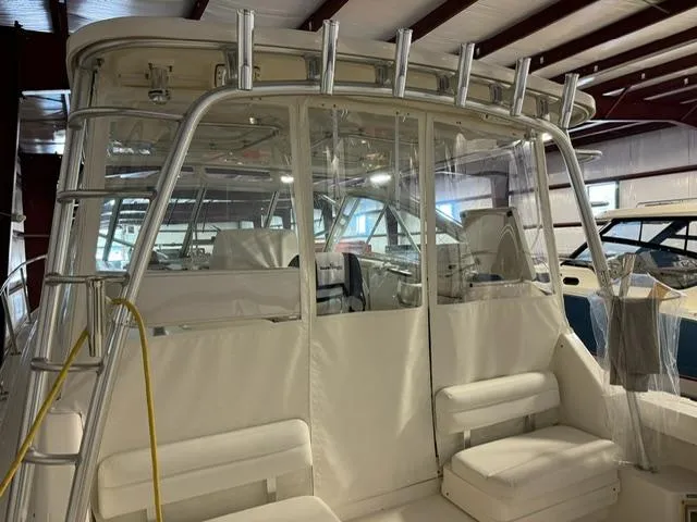 Slide: The Image of 2006 Rampage 33 Express boat interior with seating and rod holders in a storage facility. - 4