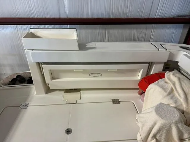 Slide: The Image of 2006 Rampage 33 Express boat interior with storage compartment and white upholstery. - 7