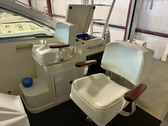 Slide: The Image of 2006 Rampage 33 Express boat interior with white captain chairs and wooden armrests. - 9