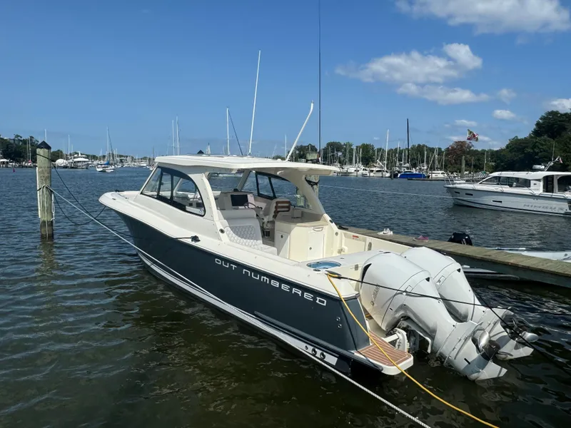 Slide: The Image of 2019 Southport 33 DC boat docked in a marina under a clear blue sky. - 0