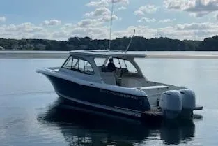 Slide: The Image of 2019 Southport 33 DC boat on calm water with clear sky. - 1
