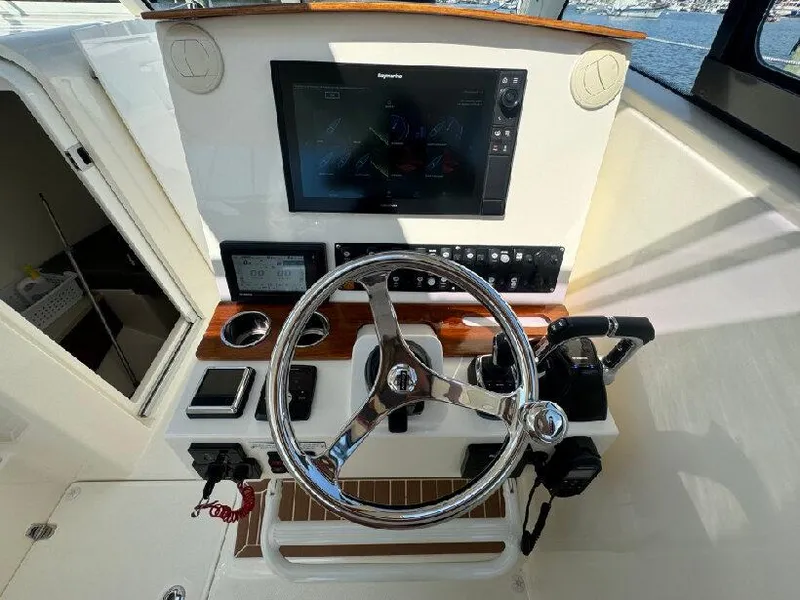 Slide: The Image of 2019 Southport 33 DC boat helm with steering wheel and navigation display. - 11