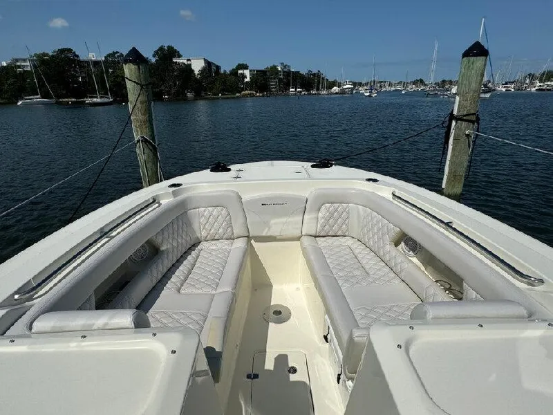 Slide: The Image of 2019 Southport 33 DC boat with spacious seating, docked in a scenic marina. - 13
