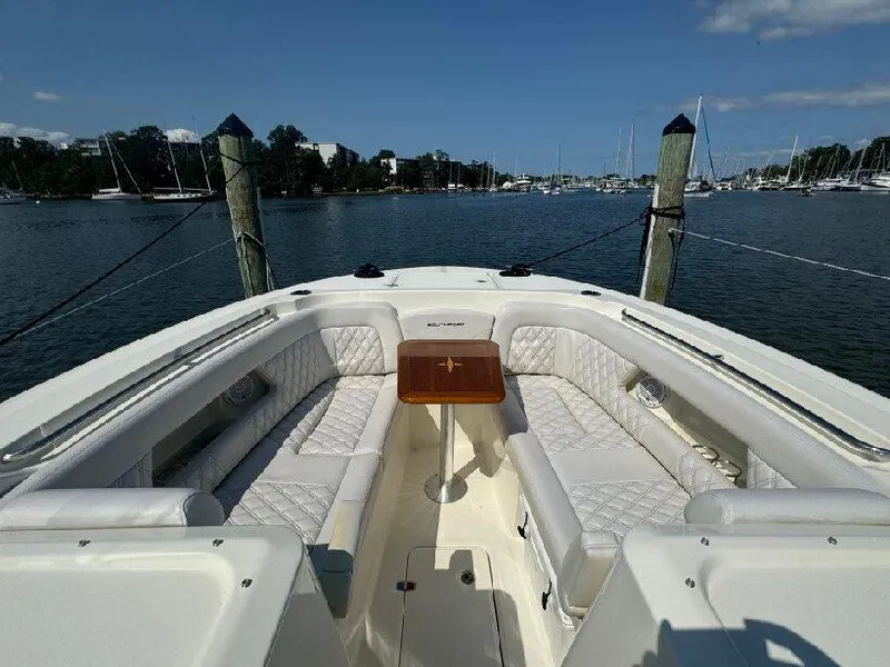 Slide: The Image of 2019 Southport 33 DC boat with spacious seating, docked in a scenic marina. - 14