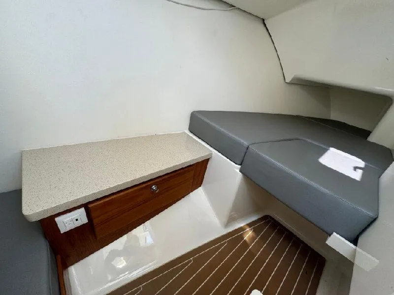 Slide: The Image of 2019 Southport 33 DC cabin interior with cushioned seating and wooden cabinetry. - 16