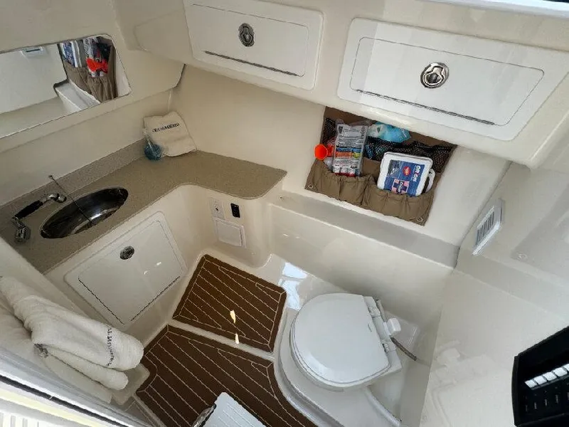 Slide: The Image of 2019 Southport 33 DC boat interior with sink, toilet, and storage compartments. - 19