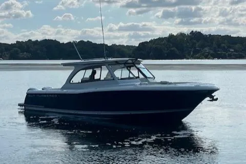 Slide: The Image of 2019 Southport 33 DC boat on calm water under a cloudy sky. - 2
