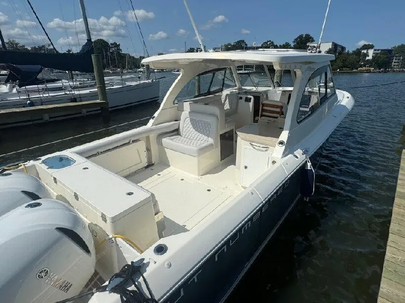 Slide: The Image of 2019 Southport 33 DC boat docked at marina, featuring spacious seating and twin engines. - 4
