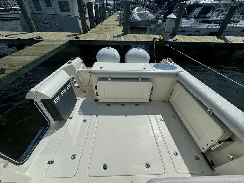 Slide: The Image of 2019 Southport 33 DC boat docked, featuring spacious deck and twin engines. - 5