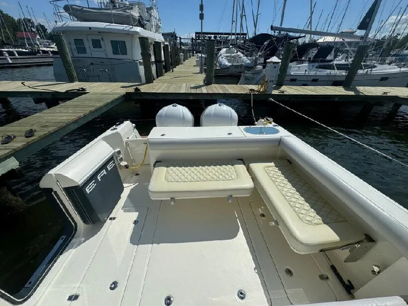 Slide: The Image of 2019 Southport 33 DC boat docked, featuring spacious seating and twin engines. - 6