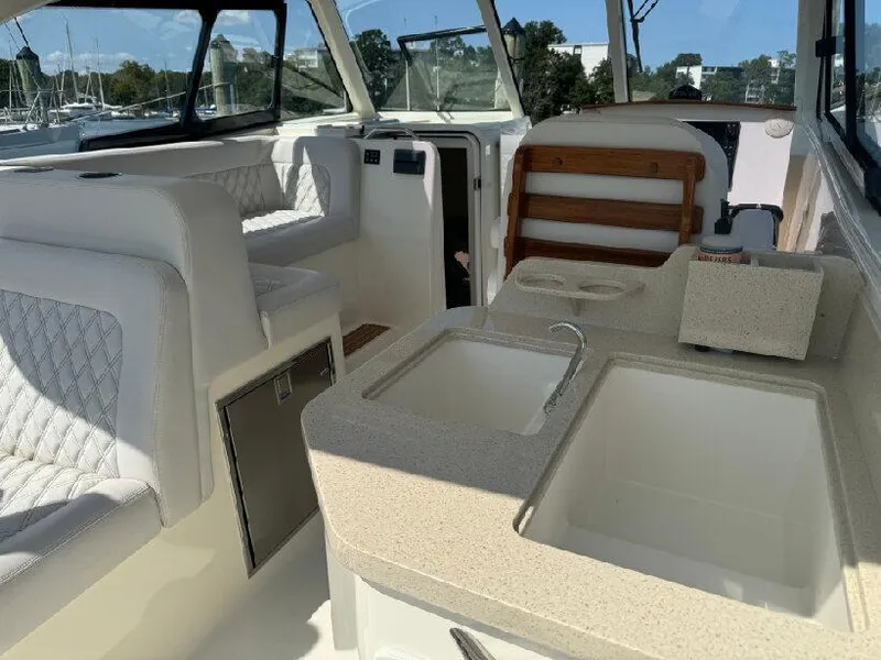 Slide: The Image of 2019 Southport 33 DC boat interior with seating and kitchenette area. - 7