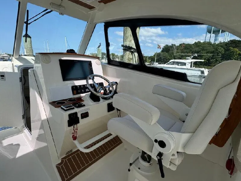 Slide: The Image of 2019 Southport 33 DC boat cockpit with steering wheel and navigation controls. - 9