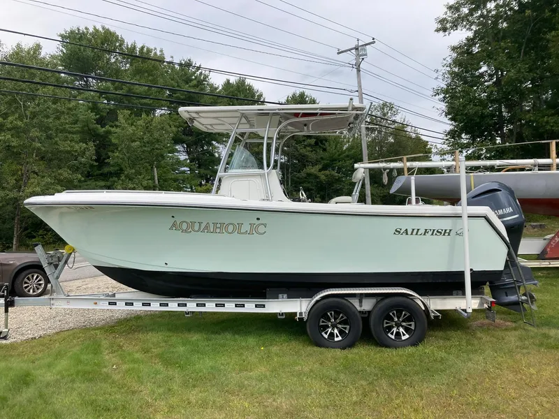 Slide: The Image of 2011 Sailfish 2360 CC boat on trailer, parked on grass. - 5