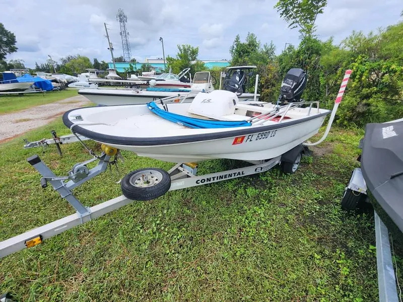 Slide: The Image of 2000 Boston Whaler Sport 13 boat on trailer, parked on grass. - 11