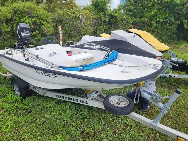 Slide: The Image of 2000 Boston Whaler Sport 13 boat on trailer, parked on grass. - 12