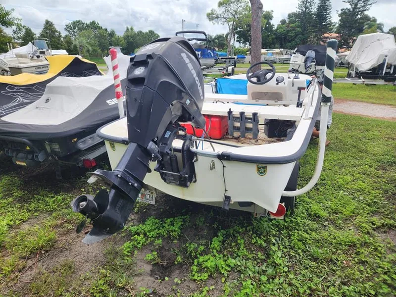 Slide: The Image of 2000 Boston Whaler Sport 13 boat with outboard motor in a grassy area. - 2