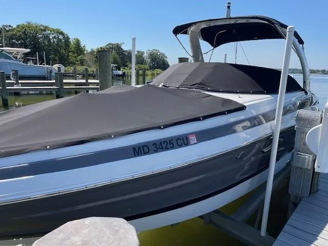 Slide: The Image of 2023 Crownline 290 XSS boat docked with cover, sunny day. - 1